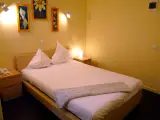 Standard Double room seen at an angle, with wooden nightstands, a telephone and a wall radiator